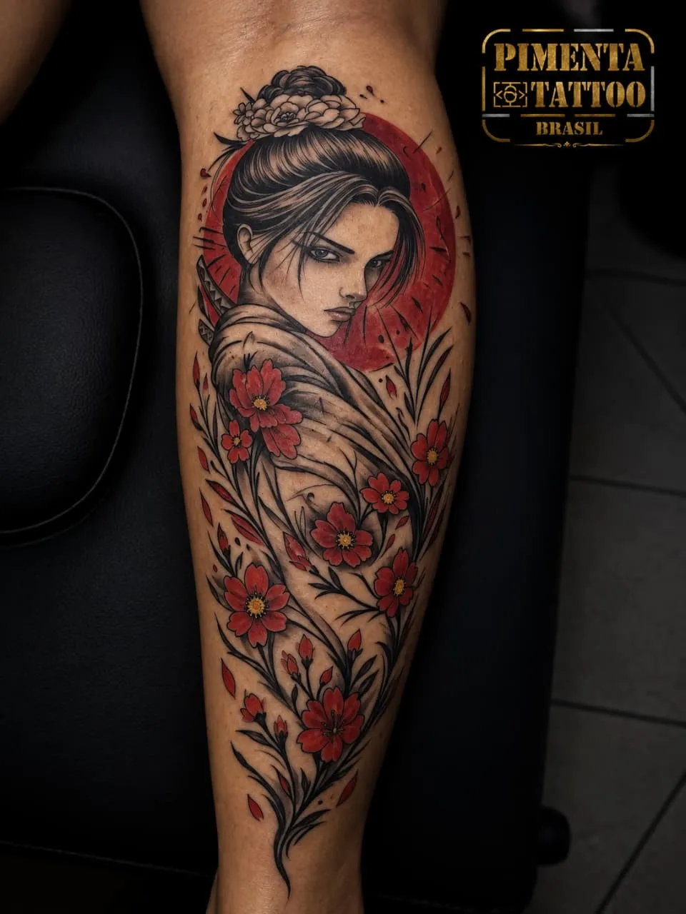 Tatuagem de gueixa com katana, sol vermelho e flores de cerejeira na panturrilha