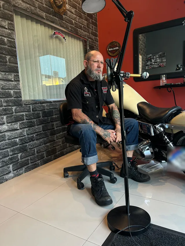 Ambiente do estúdio com parede de tijolos, luminária de trabalho e motocicleta customizada